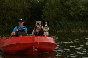 Coaches and Tess the dog watching from the safety boat