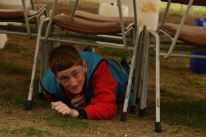 Crawling under chairs in the obstacle course