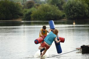 Yellow and Blue team head-to-head on the water with pugil sticks