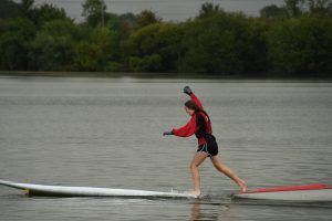A junior running the gauntlet of floating SUP and windsurf boards