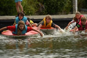 Blue and yellow teams paddling boats
